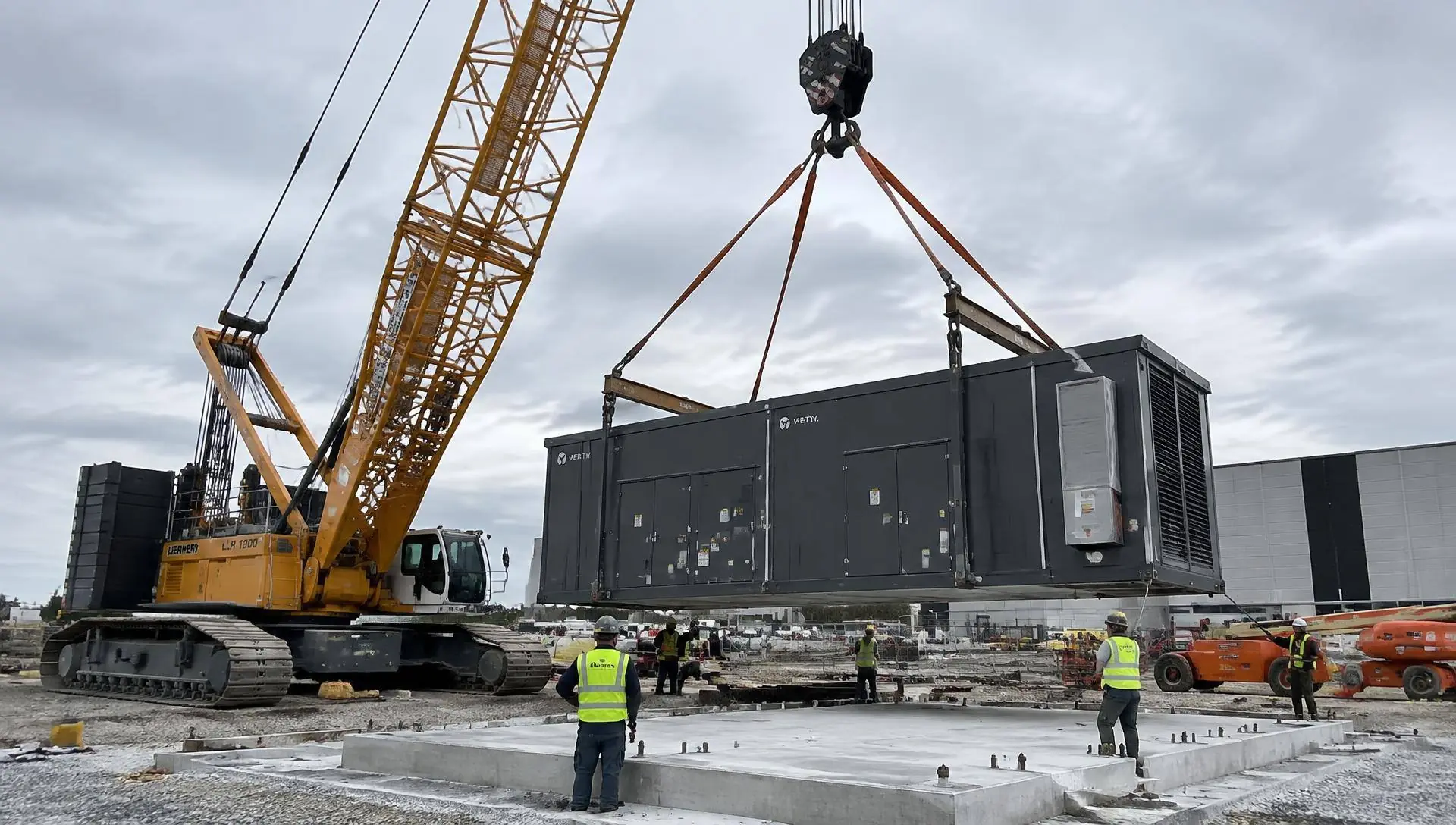 Photo of a modular data center unit being lifted on a construction site